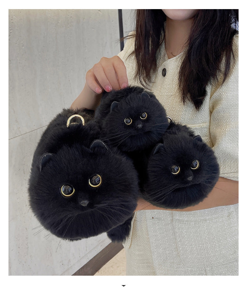 Black cat kitten bag purse held in woman's hands